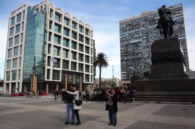 Turistas se fotografían en la Plaza Independencia de Montevideo.