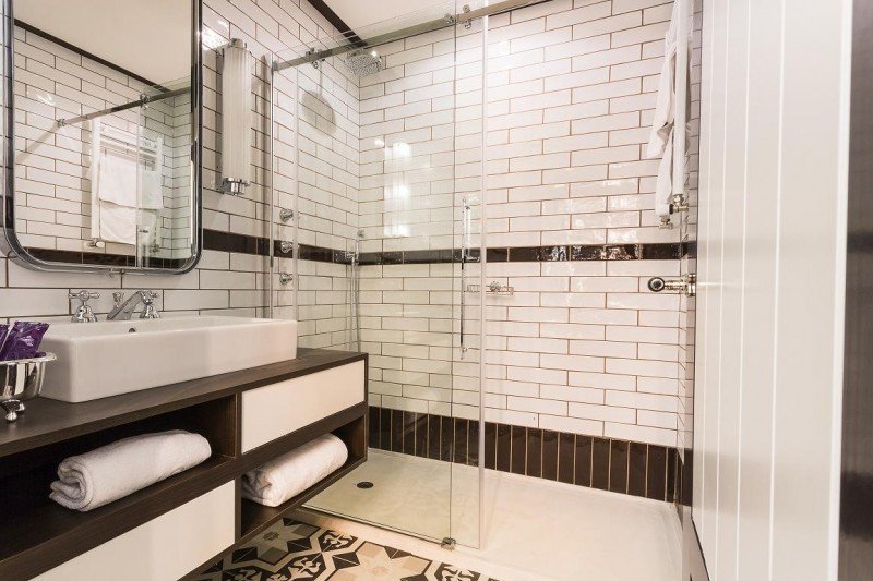 Los baños de las habitaciones, todos con ducha y azulejos vintage.